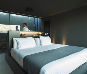 1 dormitorio con 1 cama grande con almohadas blancas en VIVOOD Landscape Hotel & Spa - Designed for Adults, en Benimantell