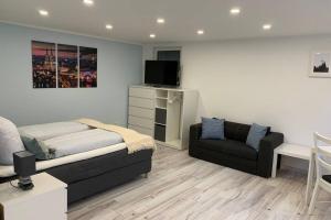 1 dormitorio con cama, sofá y TV en Attention Football Fans I Modern renovated apartment only 36 min away from Cologne stadium, en Bonn