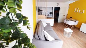 ein Wohnzimmer mit Sofa und Tisch in der Unterkunft Studio familial 30m2 Les Goelands - grand balcon vue forêt in Saint-Jean-de-Monts