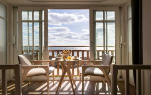 een eetkamer met een tafel en stoelen en een balkon bij Hotel Les Vikings in Le Croisic