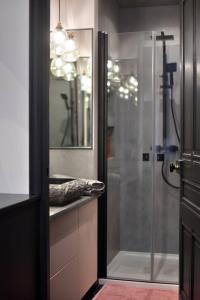 La salle de bains est pourvue d'une douche en verre et d'un lavabo. dans l'établissement La Suite en Rose - Spa - Brotteaux, à Lyon