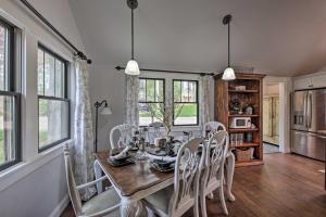 uma sala de jantar com mesa, cadeiras e janelas em Big Cedar Lake House Views, 100 Ft to Water! em Hartford