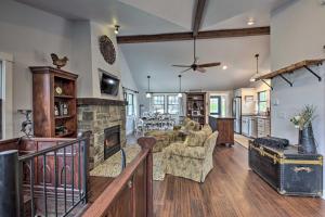 a living room with a stone fireplace and a couch at Big Cedar Lake House Views, 100 Ft to Water! in Hartford