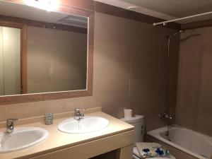 een badkamer met 2 wastafels, een spiegel en een toilet bij Tortugas 16 in Carboneras