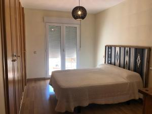 een slaapkamer met een bed en een groot raam bij Tortugas 16 in Carboneras