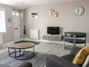 a living room with a couch and a table and a tv at Seascape in Burntisland