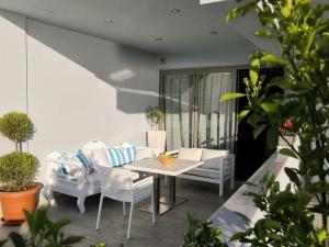 a patio with a white table and chairs at Hotel George suite 2 in Limenas