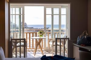 Una habitación con balcón con mesa y sillas. en Hotel Les Vikings, en Le Croisic