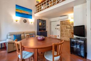 a living room with a wooden table and a couch at Ferret Apartment in Alghero