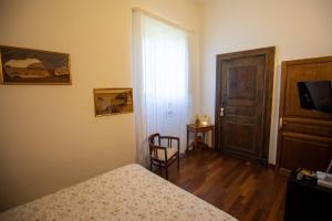 a bedroom with a bed and a door and a chair at Il Castello di San Sergio in Centola