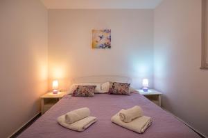 a bedroom with a purple bed with two pillows at Villa Nika in Jasenice +81 photos