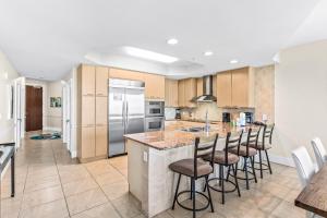 a kitchen with a large island with bar stools at Caribe 212C in Orange Beach