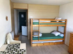 a room with two bunk beds in a room at Le Vostok Zodiaque Soyouz in Le Corbier
