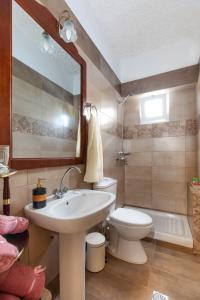 a bathroom with a sink and a toilet and a mirror at Margarita luxury apartment 1 in Faliraki