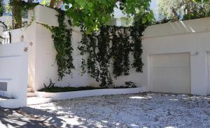 una cerca blanca con una puerta de garaje blanca en Villa Tortuga, en Marbella