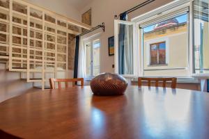 a large wooden table with chairs and a large window at Ferret Apartment in Alghero