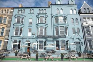 a blue building with tables in front of it at The Glengower in Aberystwyth
