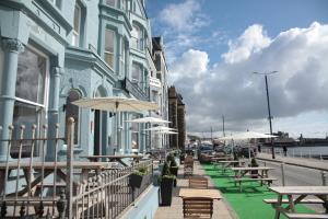 a row of tables and umbrellas outside of a building at The Glengower in Aberystwyth