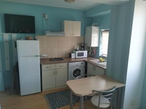 a kitchen with a white refrigerator and a table at Apartament Select Mamaia in Mamaia