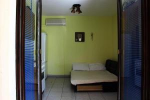 a room with a small bed in a green room at Josip 1 Gajac in Novalja