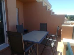 una mesa azul y sillas en el balcón en Jacaranda A, en Pedreguer