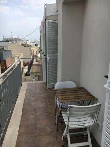un balcone con tavolo e sedie su un edificio di Appartamento 13 a Polignano a Mare