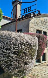 um edifício com um arbusto florido à sua frente em Hotel A Forxa Cafetería Restaurante em Carballeira