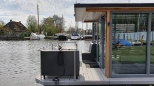 una casa con TV en un muelle junto al agua en Havenlodge Heeg en Heeg