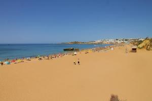 a beach filled with lots of people on a sunny day at Luna Clube Oceano in Albufeira