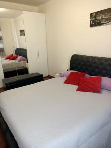 - une chambre avec un lit doté d'oreillers rouges dans l'établissement Luna, à Cavalcaselle