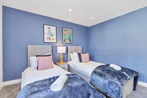 two beds in a room with blue walls at RIGHT ON - BRIGHTON - By My Getaways in Brighton & Hove