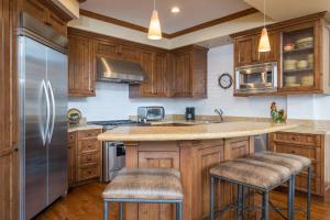 a kitchen with wooden cabinets and a stainless steel refrigerator at Colonnade Residence - 14 in Ketchum
