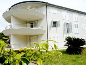 a large white building with a round balcony at Apartment Allegra in Banjole