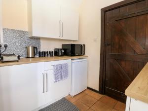 a kitchen with white cabinets and a wooden door at Waterloo Retreat in Norwich