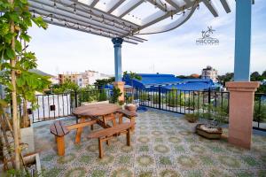 a patio with a table and benches on a balcony at Hacoda Homestay in Con Dao