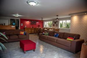 a living room with two brown couches and a red wall at Hotel Alvorada do Sol in Sao Paulo