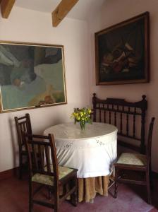 a table with a vase of flowers and two chairs at Casica de Perintín Cottage in Ricote