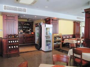 ein Zimmer mit Kühlschrank in einem Restaurant mit Tischen in der Unterkunft Maverick Hotel in Sonnenstrand