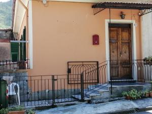 une maison avec une porte en bois et des escaliers dans l'établissement I Limoni di Matteo, à Biassa
