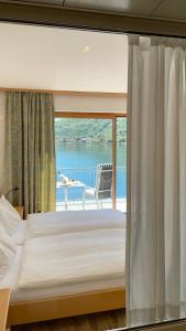 a bedroom with a bed and a view of a balcony at Tresa Bay Hotel in Ponte Tresa