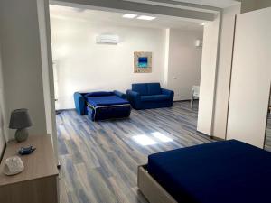 Pokój z 2 niebieskimi krzesłami, łóżkiem i kanapą w obiekcie Appartamenti Acquazzurra w mieście Portoferraio
