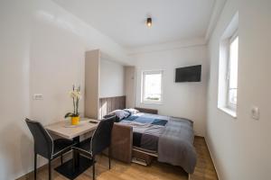1 dormitorio con 1 cama, mesa y sillas en Apartmaji Prton Bovec en Bovec