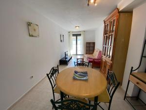 jadalnia z drewnianym stołem i krzesłami w obiekcie Apartamentos Sotavento Altamar w mieście Alcossebre