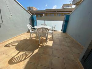 a patio with a table and chairs on a balcony at Apartamentos Sotavento Altamar in Alcossebre