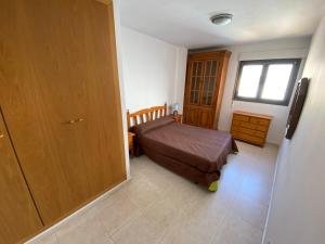 mała sypialnia z łóżkiem i oknem w obiekcie Apartamentos Sotavento Altamar w mieście Alcossebre
