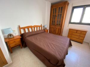 1 dormitorio con 1 cama, vestidor y ventana en Apartamentos Sotavento Altamar, en Alcossebre