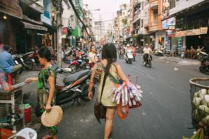 two women walking down a busy city street at J&K Hotel in Ho Chi Minh City