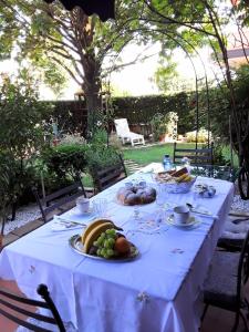 une table blanche avec des assiettes de nourriture dans l'établissement B&B LA ROSA GIALLA, à Maranello