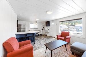 a kitchen and living room with red chairs and a table at Sitting on the Dock of the Bay in Athol