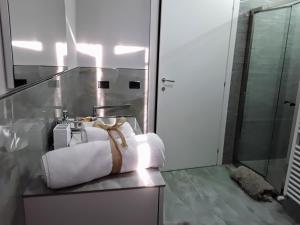 - une salle de bains pourvue de serviettes sur un comptoir à côté d'une douche dans l'établissement B&B LA ROSA GIALLA, à Maranello